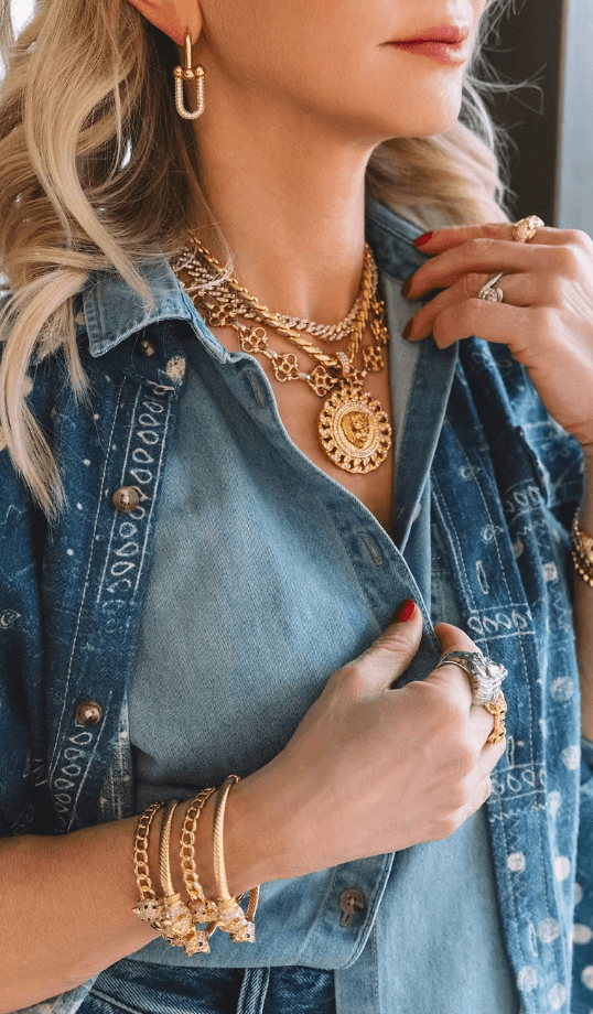 tali kogan wearing layered gold necklaces, stacked bracelets, statement rings, and hoop earrings from the Malkari jewelry collection