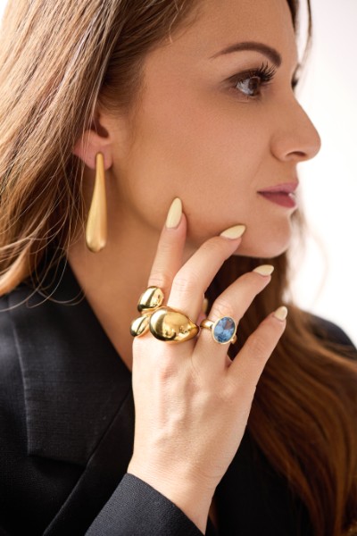 Model wearing MALKARI gold earrings and rings